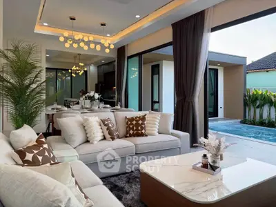 Luxurious open-plan living room with pool view, modern decor, and elegant lighting in a stylish home.