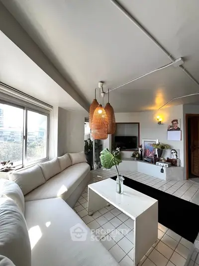Spacious living room with modern decor and large windows offering city views.