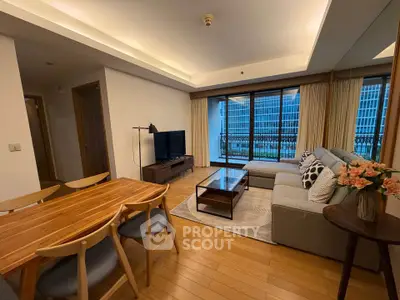 Spacious living room with modern decor and city view, featuring a cozy sofa and elegant dining area.