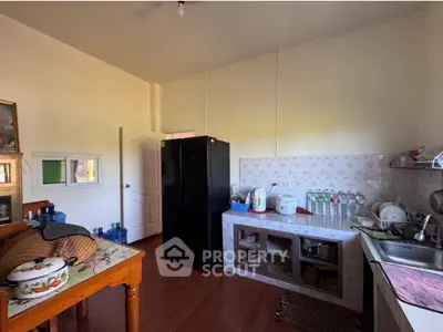 Cozy kitchen with black fridge and ample storage space, perfect for culinary enthusiasts.
