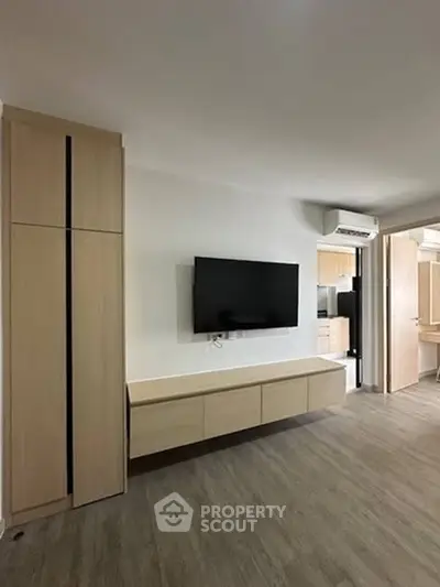 Modern living room with wall-mounted TV and sleek wooden cabinetry