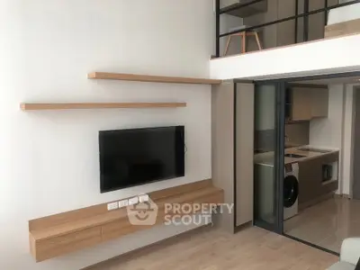 Modern apartment interior with wall-mounted TV and open kitchen layout