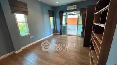 Spacious living room with gleaming hardwood floors, modern air conditioning, and ample natural light from large balcony doors.