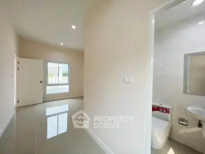 Bright interior with glossy tile flooring and modern bathroom access