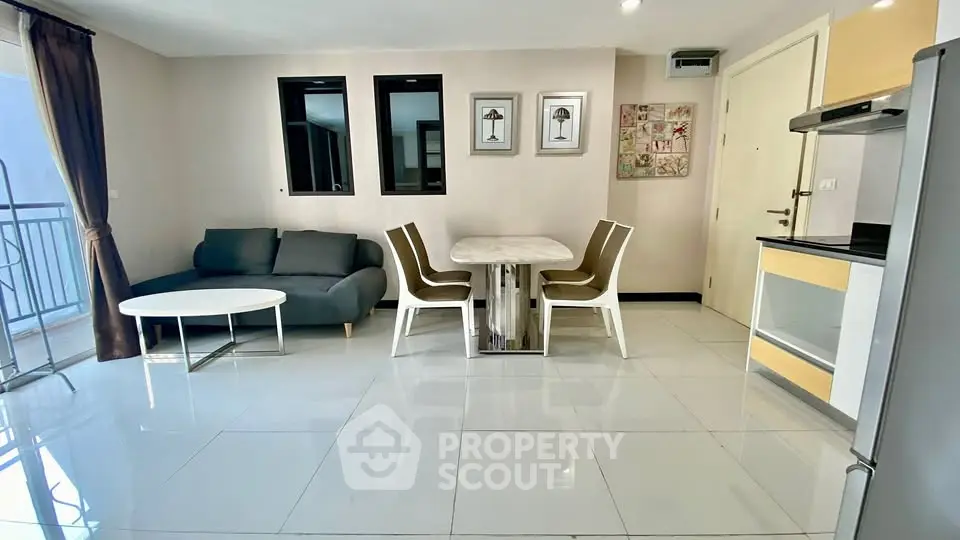 Modern open-plan living room with dining area and balcony access in a stylish apartment.