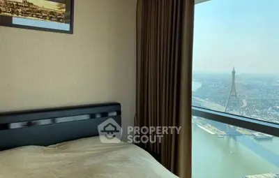 Luxurious bedroom with stunning city and river view from high-rise window.