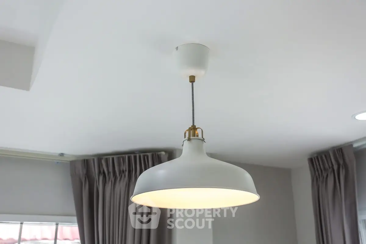 Modern interior with stylish pendant light and elegant curtains