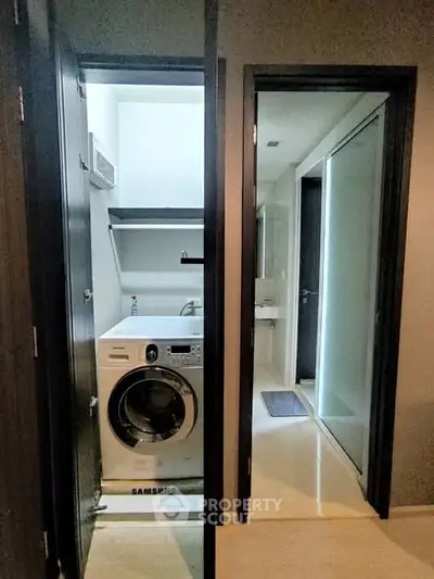 Modern apartment with laundry area featuring Samsung washing machine and adjacent bathroom.