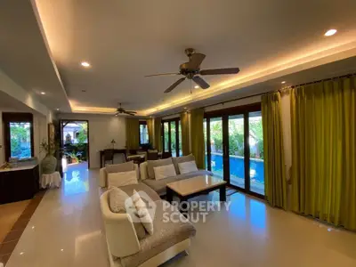 Luxurious living room with pool view, modern furniture, and elegant lighting in a tropical villa.