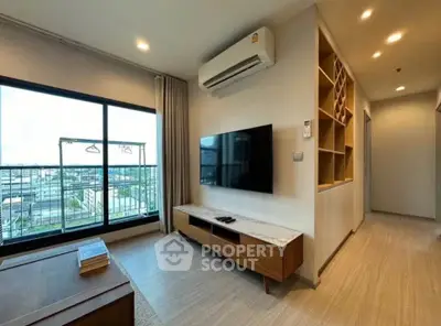 Modern living room with large window and stylish wooden furniture in a high-rise apartment.