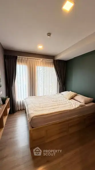 Cozy bedroom with modern decor and large window for natural light