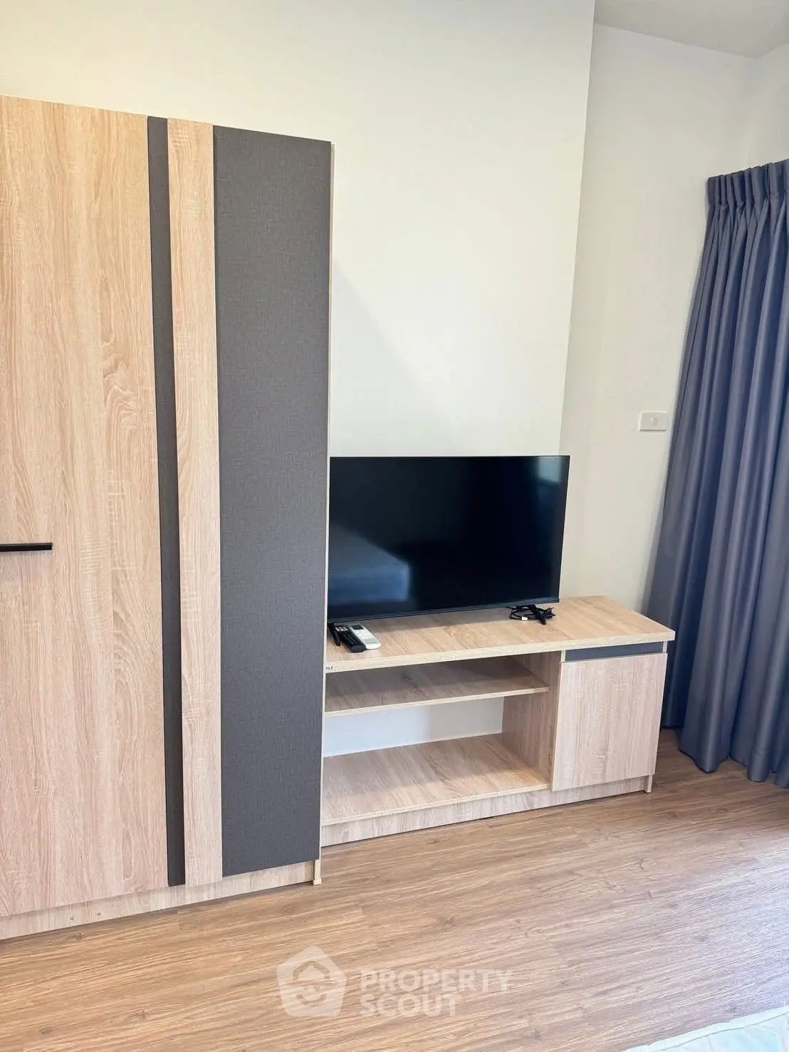 Modern living room with sleek TV stand and wooden flooring, perfect for cozy entertainment.