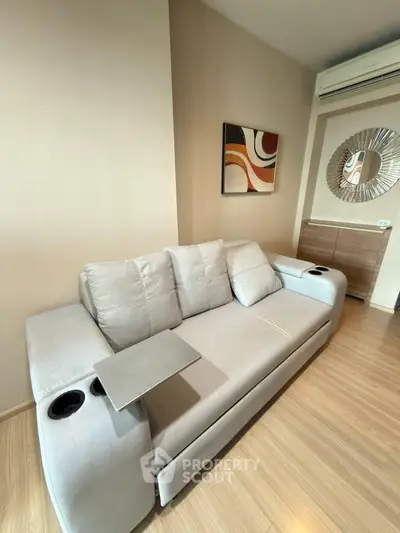 Modern living room with stylish sofa and wall art in a cozy apartment setting.
