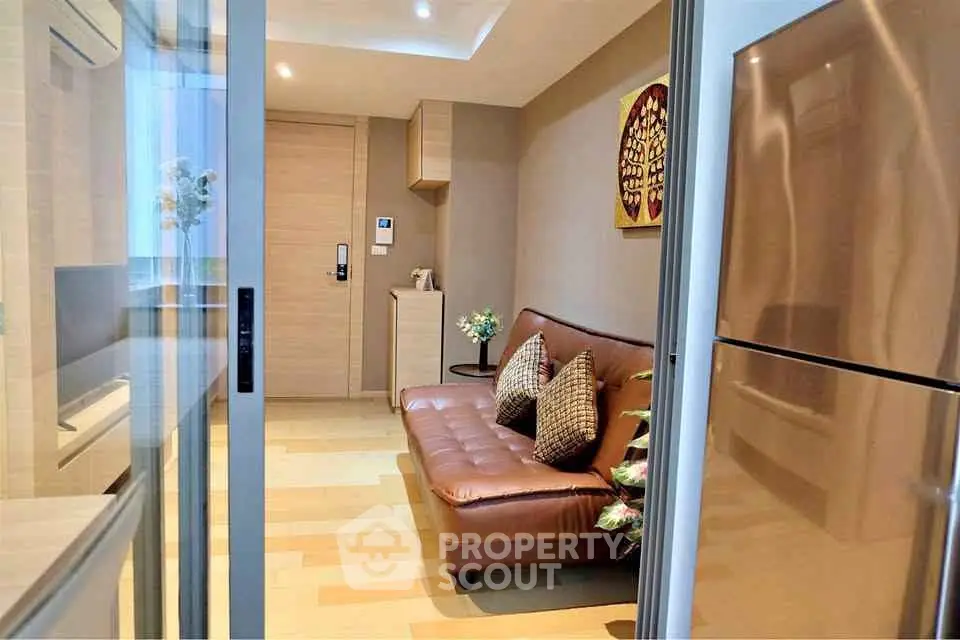 Modern living room with sleek design and stainless steel fridge, perfect for urban living.