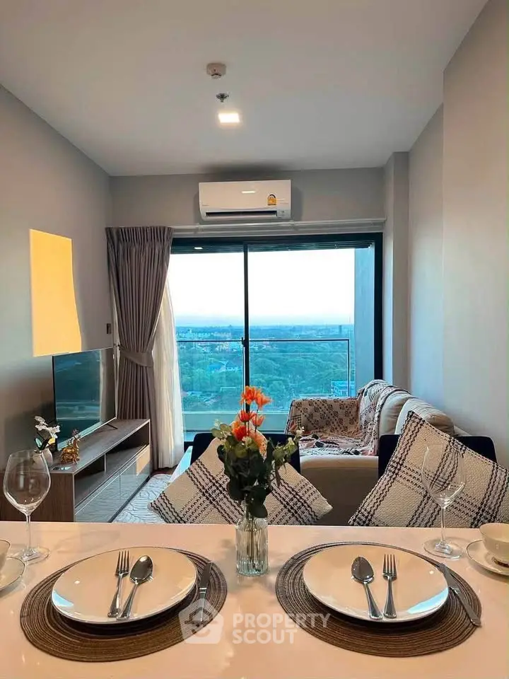 Modern living room with balcony view, stylish decor, and dining setup in a high-rise apartment.