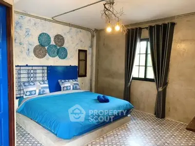 Chic industrial-style bedroom with blue accents and unique lighting.