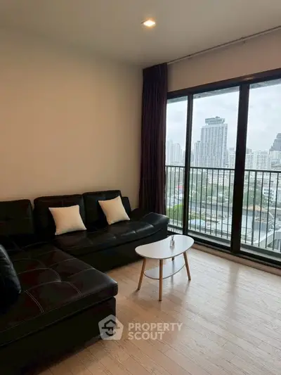 Modern living room with city view and stylish black leather sofa