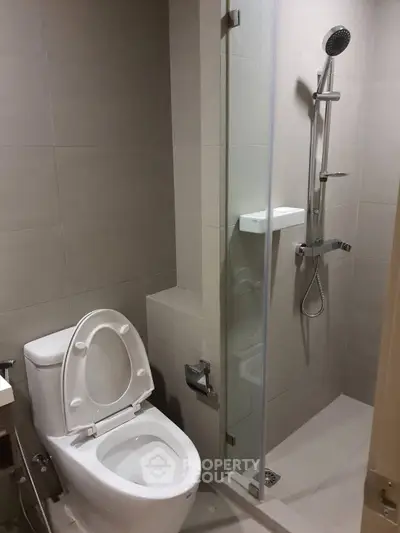 Modern bathroom with sleek shower and toilet in minimalist design.