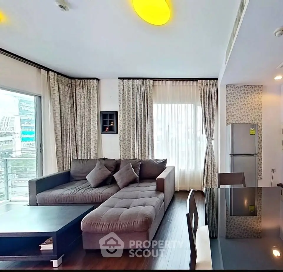 Spacious modern living room with large windows and stylish furniture in a luxury apartment.