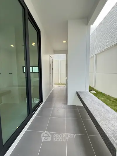 Modern outdoor corridor with sleek design and large glass doors