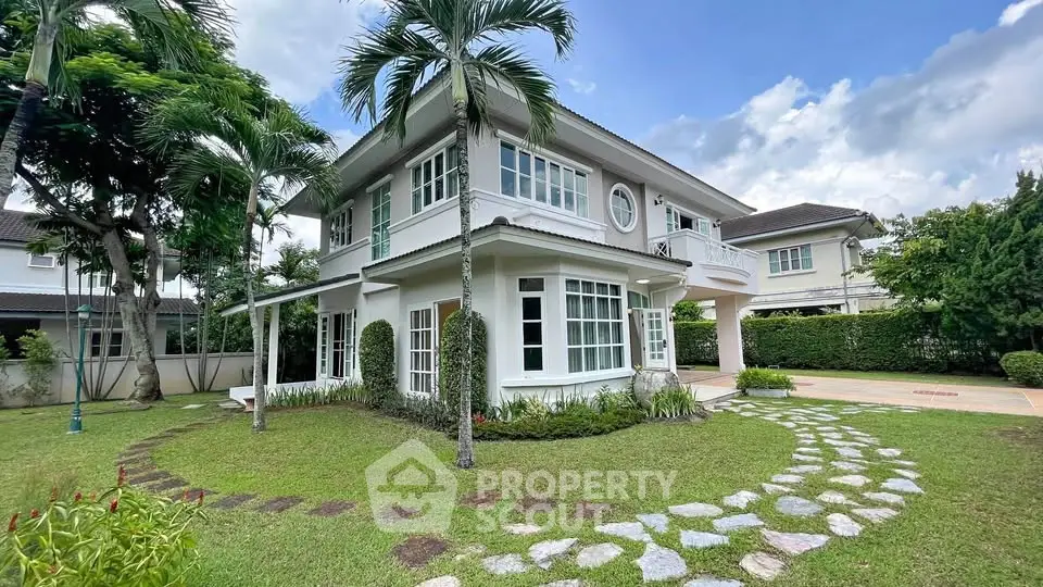 Charming two-story house with lush garden and pathway in serene neighborhood.