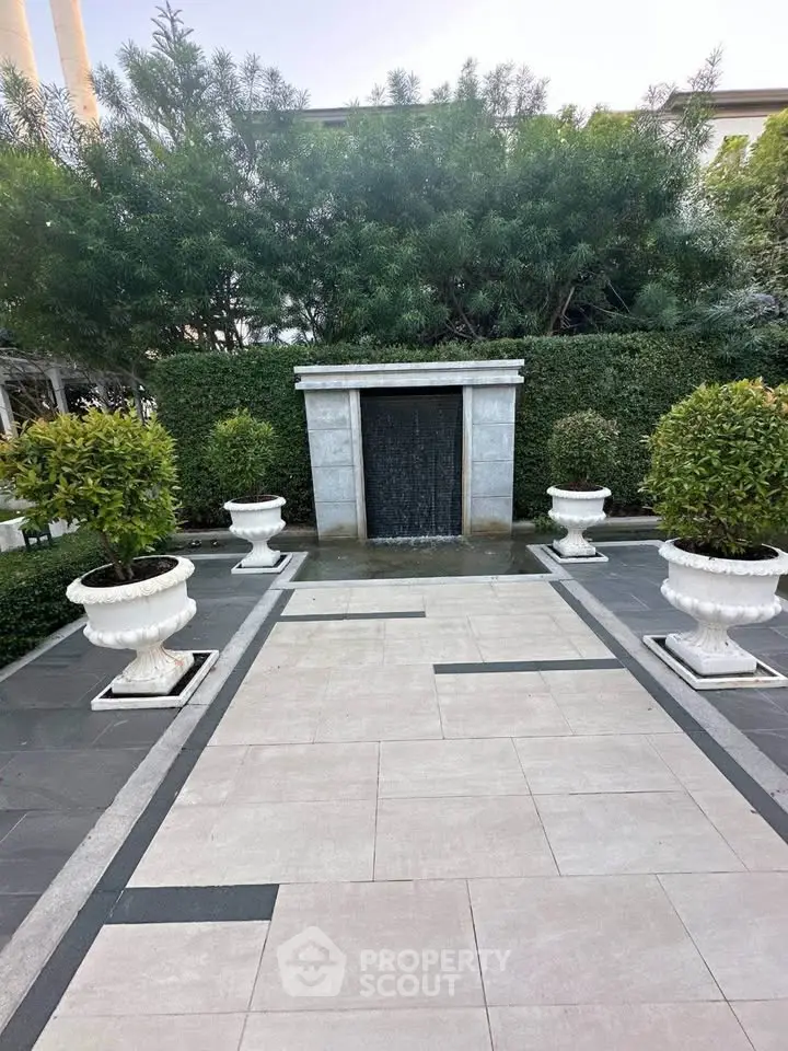 Elegant garden with modern water feature and lush greenery