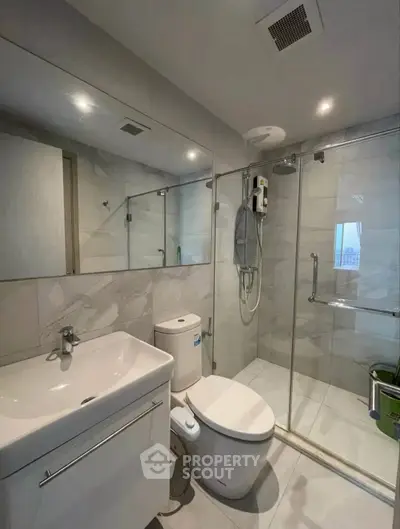 Modern bathroom with sleek fixtures and glass shower enclosure