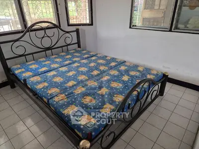 Spacious bedroom with large bed and natural light from multiple windows.