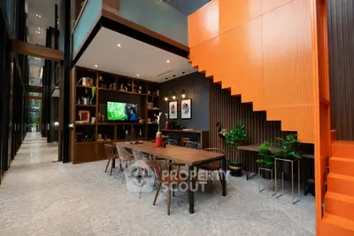 Modern open-plan living area with stylish dining set and vibrant orange staircase