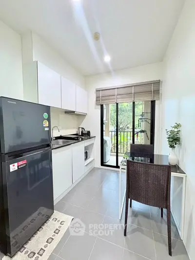 Modern kitchen with sleek appliances and balcony view in a stylish apartment