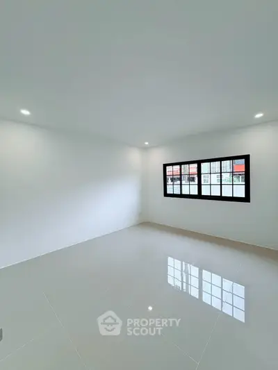 Spacious empty room with large window and glossy tiled floor, perfect for customization.