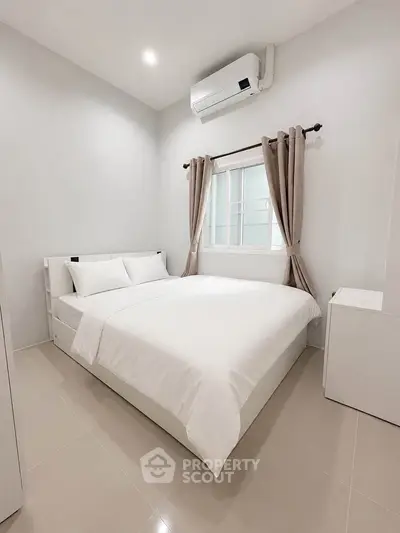 Modern minimalist bedroom with sleek design and air conditioning, perfect for comfort and relaxation.