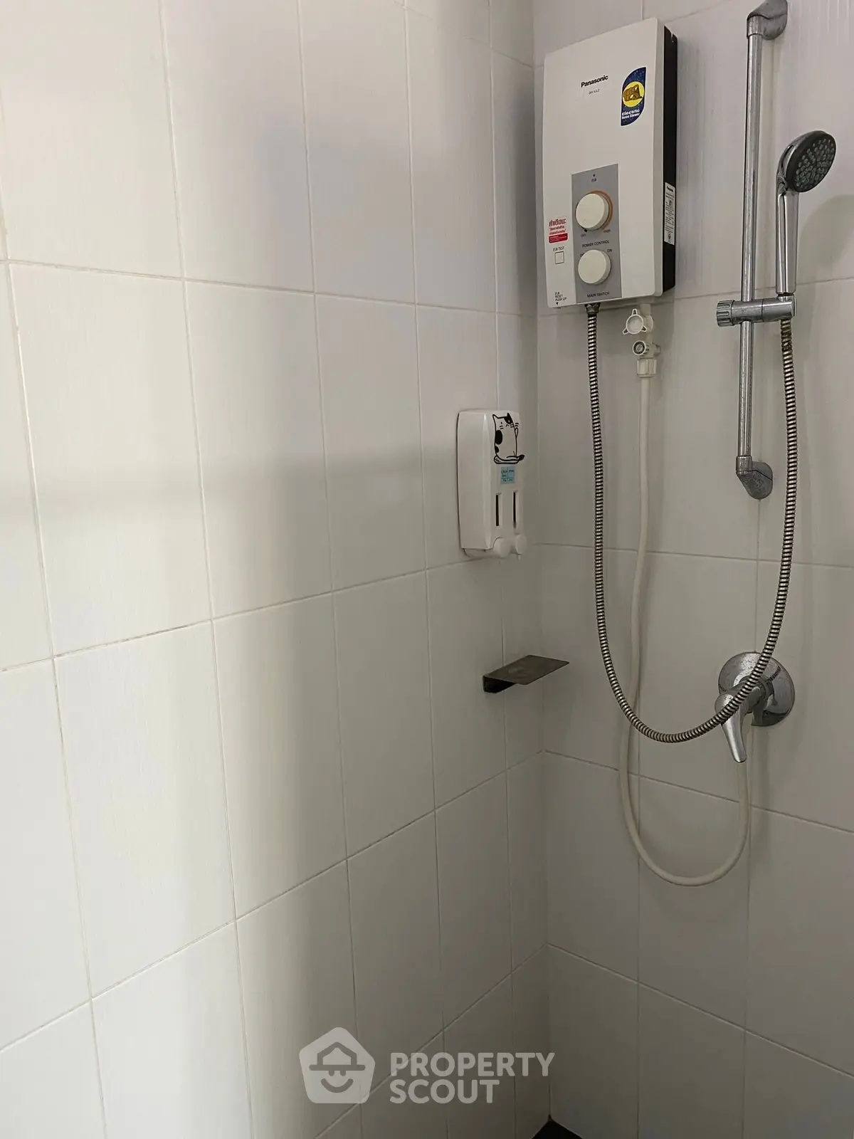 Modern bathroom with sleek shower and water heater in a minimalist design.