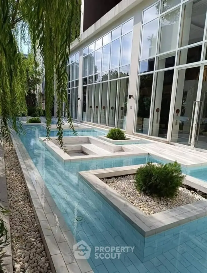 Luxurious modern building exterior with elegant pool and lush greenery, perfect for upscale living.