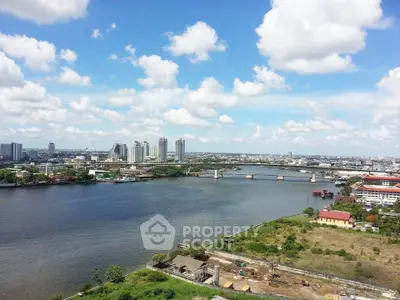 Stunning river view with city skyline and blue sky, perfect for urban living.