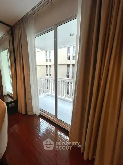 Spacious apartment with elegant balcony and floor-to-ceiling curtains, offering a serene urban view.