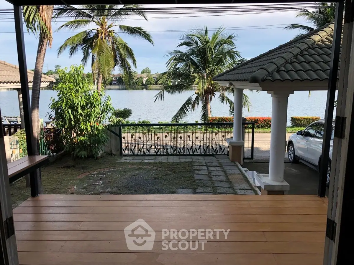 Stunning waterfront view from a spacious patio with lush palm trees and serene lake scenery.