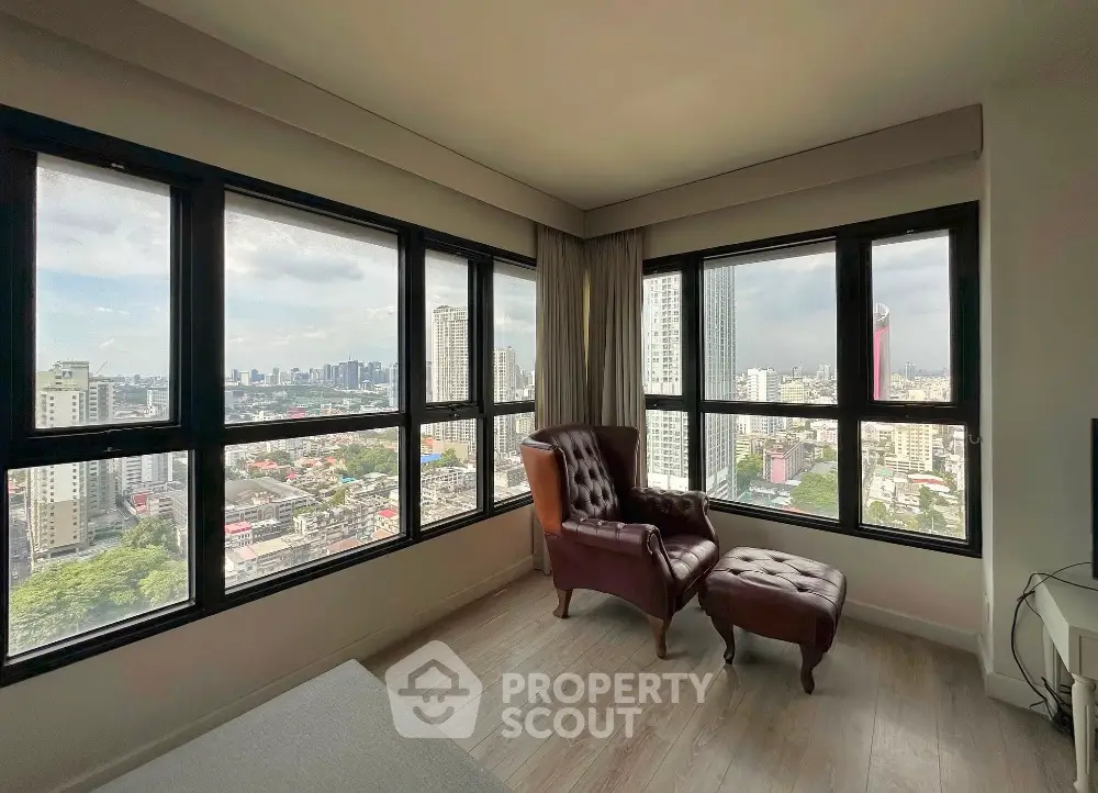 Luxurious corner unit with panoramic city views and elegant leather armchair.