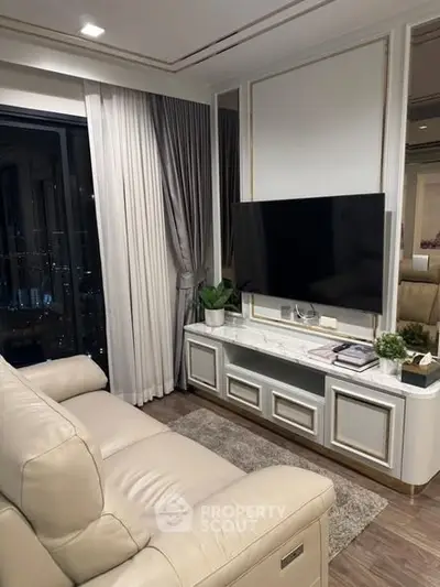 Luxurious living room with elegant decor, featuring a plush sofa and modern entertainment setup.