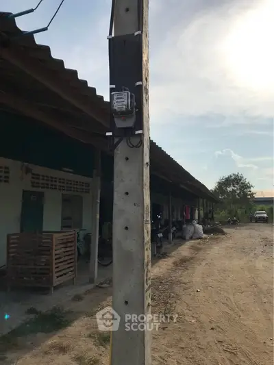 Exterior view of rural property with corrugated roof and utility pole