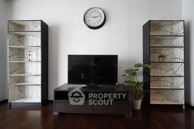 Stylish living room with modern TV stand, decorative shelves, and elegant clock on wall.