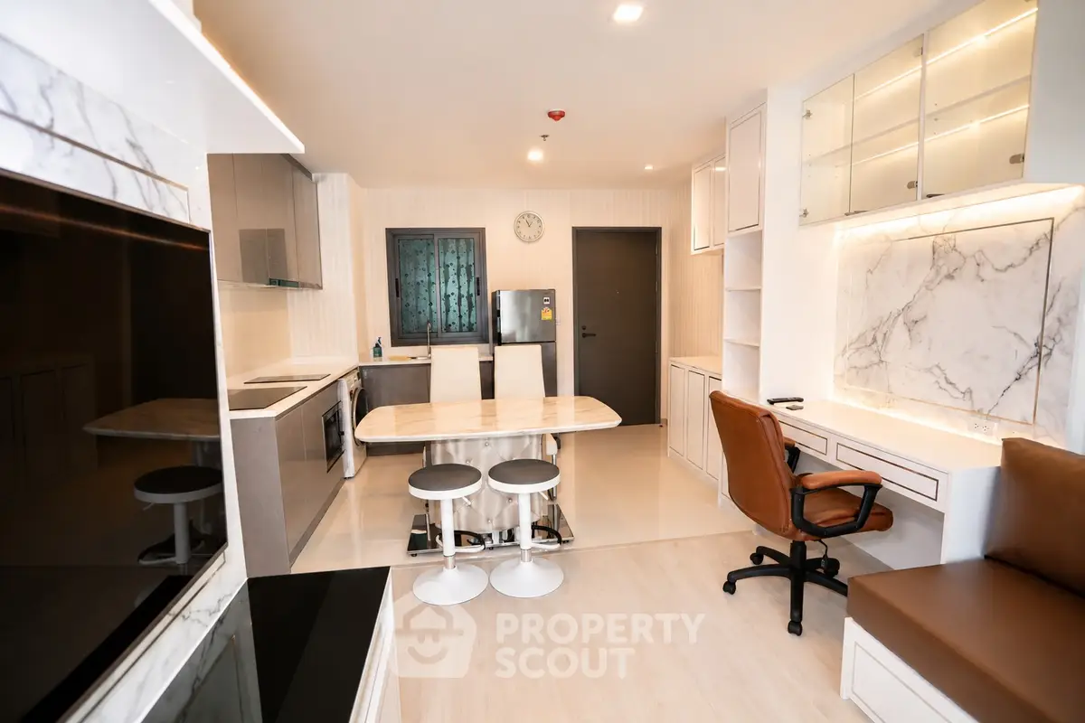 Modern kitchen with marble countertops and sleek appliances in a stylish apartment.