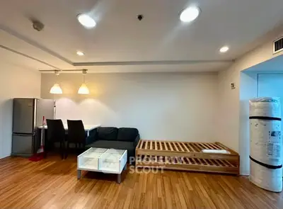 Spacious living room with modern furniture and wooden flooring in a stylish apartment.
