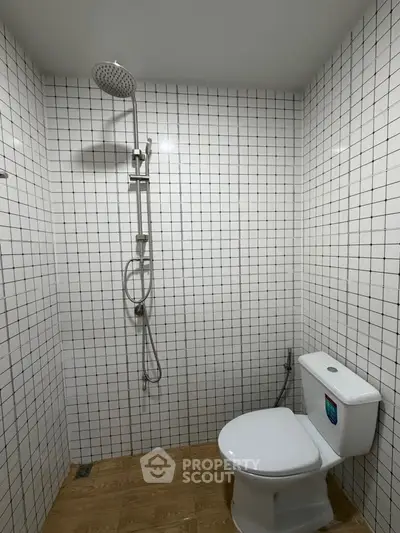 Modern bathroom with white tiled walls and sleek showerhead