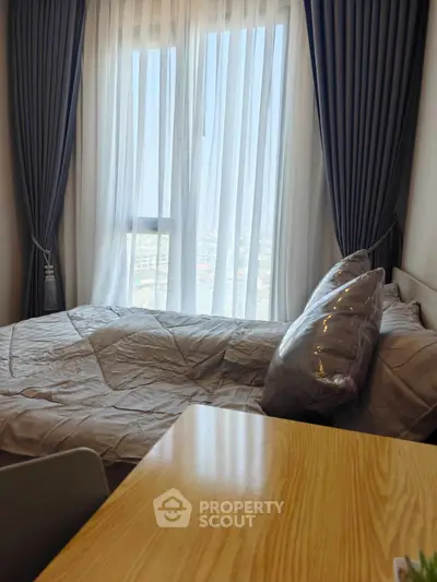 Cozy bedroom with large window and elegant curtains, perfect for natural light lovers.