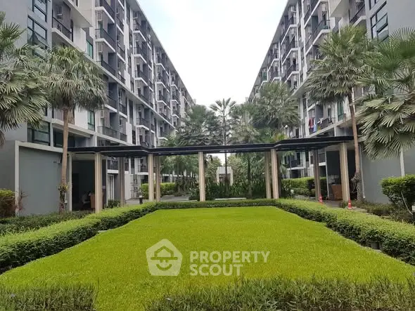 Modern apartment building with lush garden courtyard and palm trees