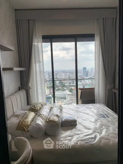 Luxurious bedroom with stunning city view from floor-to-ceiling windows in high-rise apartment.