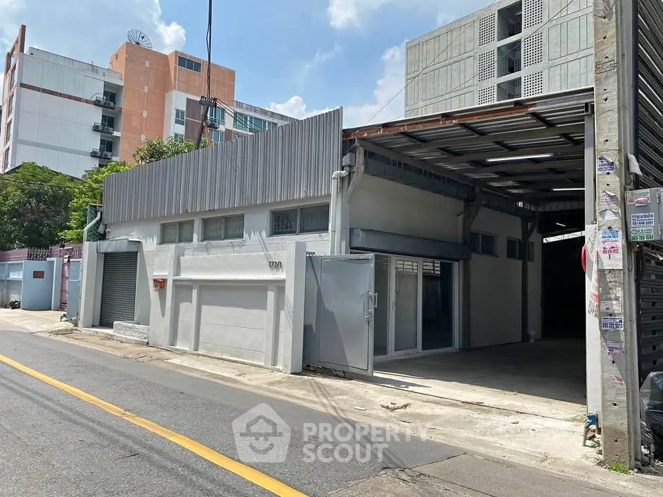 Commercial warehouse space with roller doors and ample parking in urban setting.
