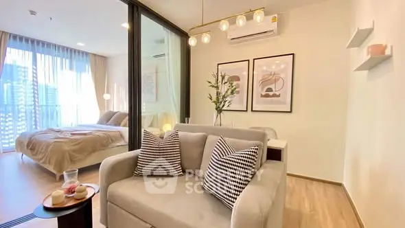Modern open-plan living room with stylish decor and cozy bedroom view, perfect for urban living.