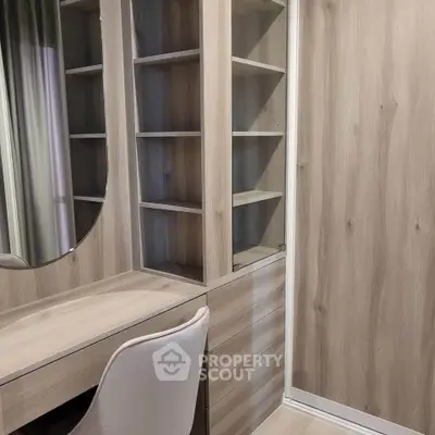 Modern study area with wooden shelves and stylish chair in a cozy home setting.